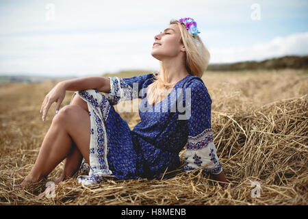 Entspannende blonde Frau im Feld Stockfoto