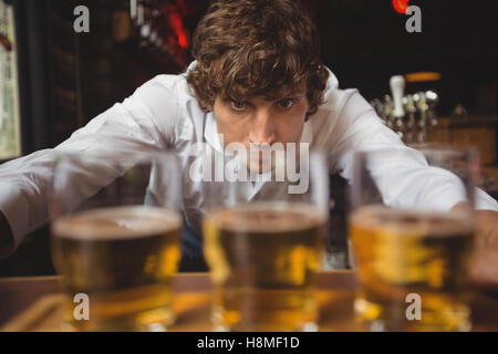 Barkeeper Futter Whisky shot Gläser am Tresen Stockfoto