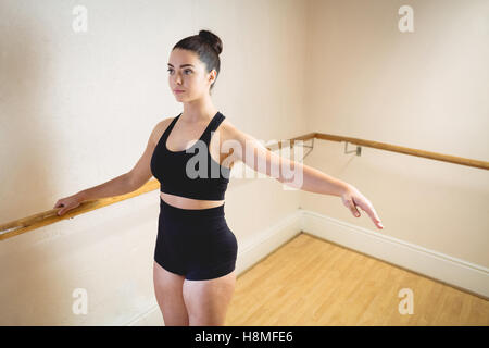 Ballerina, erstreckt sich auf einer Barre beim Praktizierenden Ballett tanzen Stockfoto