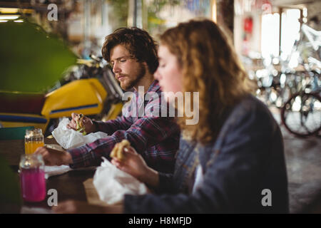 Paar am Tisch sitzen und Essen sandwich Stockfoto