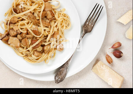 Gekochte Nudeln mit Steinpilzen auf den weißen Teller Stockfoto