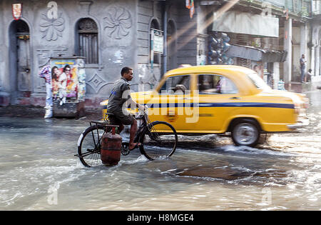 Ein Mann durchläuft während des indischen Monsuns Hochwasser in historischen Kalighat, Kolkata, Indien Stockfoto