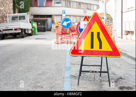 Straße Zeichen Fahrspur verengt. Im Hintergrund verschwommen ein Baustellen Stockfoto