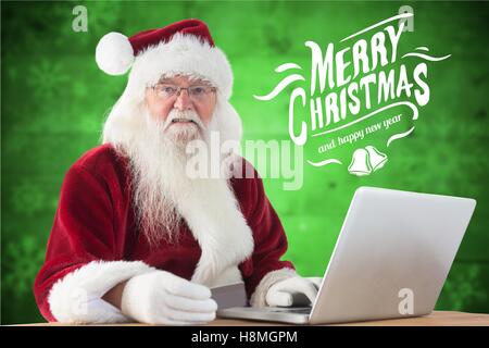 Santa Claus macht Online-shopping mit Kreditkarte auf laptop Stockfoto