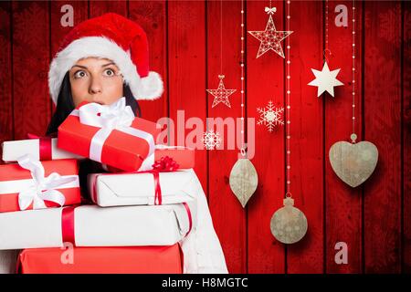 Schockiert Frau im Stapel von Geschenk-Boxen mit Weihnachtsmütze Stockfoto