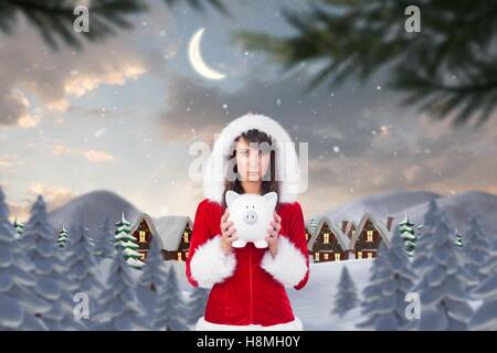 Traurige Frau in Nikolausmütze mit Sparschwein Stockfoto