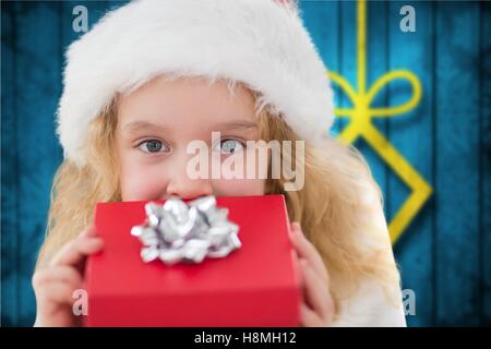 Mädchen in Weihnachtsmütze hält ein Geschenk Stockfoto