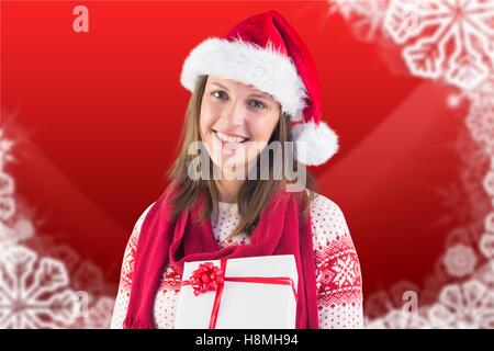 Schöne Frau in Weihnachtsmütze hält eine Weihnachtsgeschenke Stockfoto