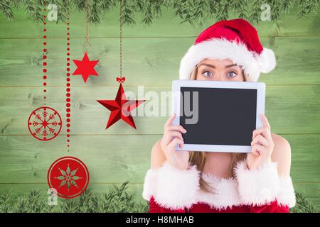 Frau in Weihnachtsmütze hält eine leere Tafel Stockfoto