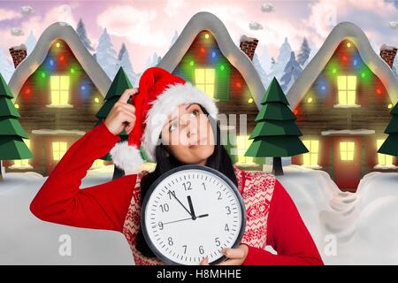 Nachdenkliche Frau in Nikolausmütze mit Uhr Stockfoto