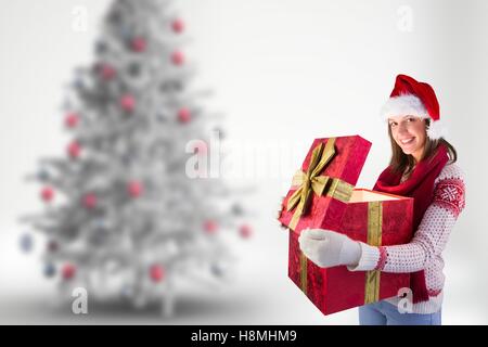 Frau in Weihnachtsmütze hält ihre große Weihnachts-Geschenk-box Stockfoto