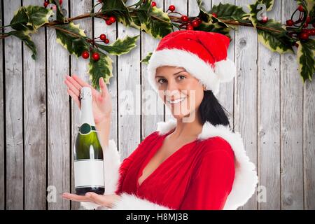 Schöne Frau in Nikolausmütze mit Champagner Flasche Stockfoto