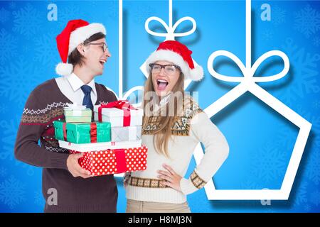 Glückliches Paar in Weihnachtsmütze hält Weihnachtsgeschenke Stockfoto