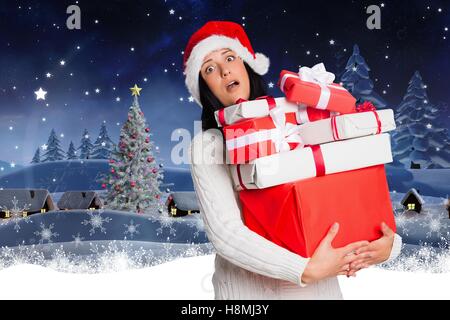 Verwirrt Frau in Nikolausmütze holding Stack von Weihnachtsgeschenken Stockfoto