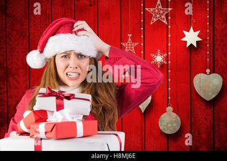 Verwirrt Frau in Santa Kostüm mit einem Stack von Weihnachtsgeschenken Stockfoto