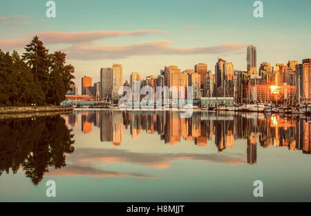 Klassische Ansicht der Skyline von Vancouver mit Stanley Park reflektiert in ruhigem Wasser bei Sonnenuntergang, Britisch-Kolumbien, Kanada Stockfoto