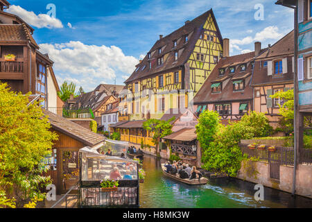 Schöne Aussicht auf die historische Stadt Colmar, auch bekannt als klein-Venedig, mit Touristen eine Bootsfahrt auf dem Kanal, Elsass, Frankreich Stockfoto