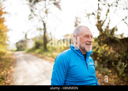Senior Läufer Lächeln auf den Lippen und im sonnigen Sommer Natur ruht. Stockfoto