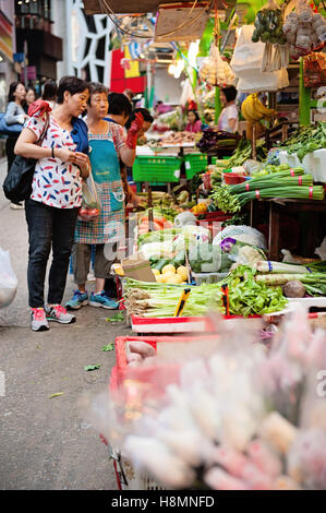Szene am Graham Street Wet Market in Hong Kong - Frau verkaufen Gemüse Stockfoto