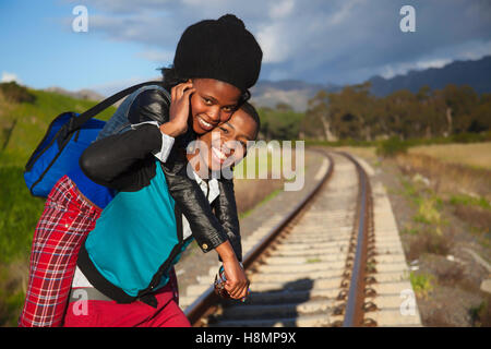 afrikanischer Mann und ein Mädchen warten auf Zug auf den Gleisen Stockfoto