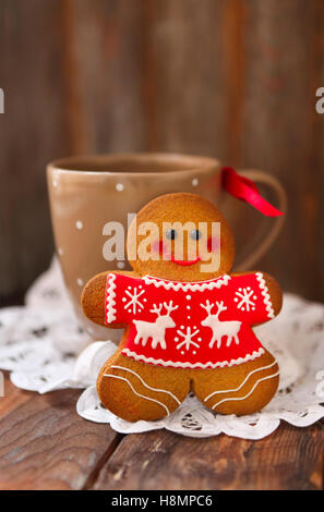 Lächelnde Weihnachten Lebkuchenmänner und Tee Tasse auf hölzernen Hintergrund. Stockfoto