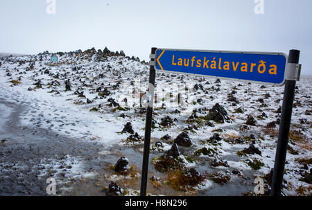 Ein Zeichen für Laufskálavarða im Süden Islands, wo Besucher Steinen als Glücksbringer Haufen Stockfoto