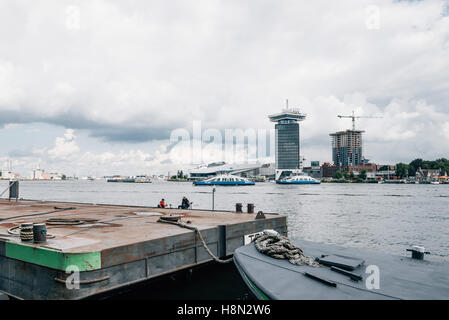 Amsterdam, Niederlande - 1 August 2016: Amsterdam Stadtbild mit Eye Film Museum auf Hintergrund und Vordergrund Boote auf eine trübe Stockfoto