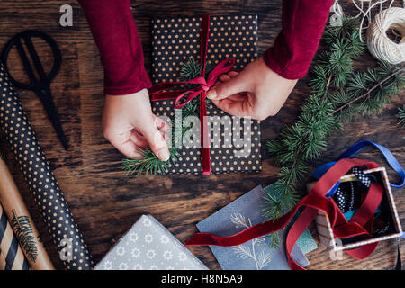 Frau binden Band auf Weihnachtsgeschenk Stockfoto