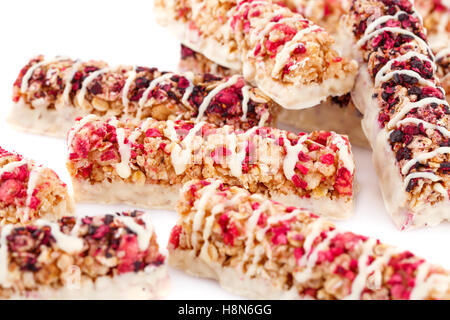 Müsliriegel mit verschiedenen Beeren und Samen auf weißem Hintergrund. Stockfoto