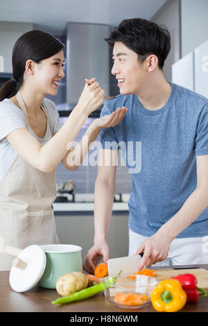 Glückliche junge chinesische paar in Küche Stockfoto