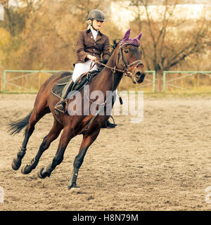 Junge Sportlerin Reitpferd auf Reitwettbewerb. Warme Farbe getönt Bild Stockfoto