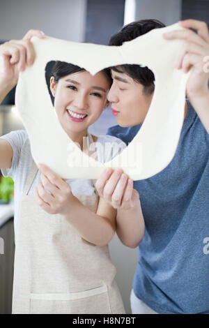 Romantische junge chinesische paar küssen in Küche Stockfoto