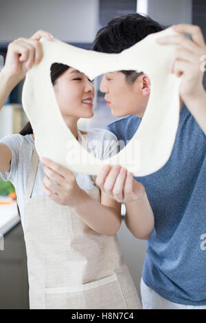 Romantische junge chinesische paar küssen in Küche Stockfoto