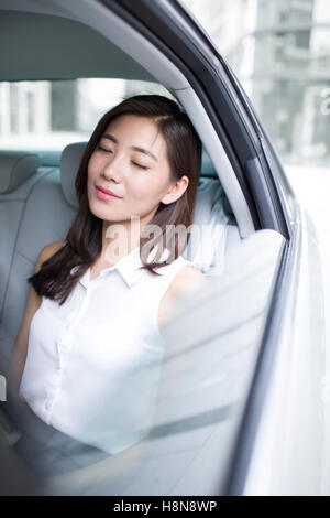 Zuversichtlich, chinesische Unternehmerin sitzt auf dem Auto Rücksitz Stockfoto