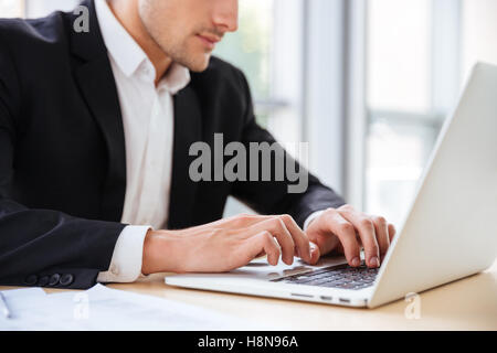 Nahaufnahme der Geschäftsmann sitzt und mit Laptop im Büro Stockfoto
