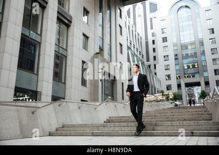 Hübscher junger Geschäftsmann walking im Freien in der Nähe von Business-center Stockfoto