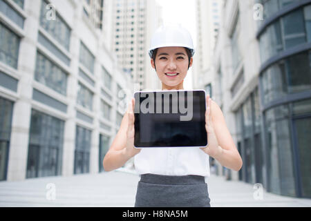 Chinesische Architektin zeigt ein digitale Tablet im freien Stockfoto