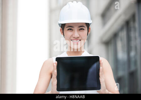 Chinesische Architektin zeigt ein digitale Tablet im freien Stockfoto