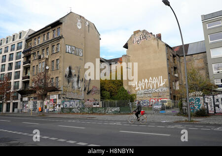 Osten Berliner Straßenszene verfallene Gebäude mit Graffiti neben neue Gebäude Eigentum auf Kopenicker Strasse, Kreuzberg, Berlin KATHY DEWITT Stockfoto