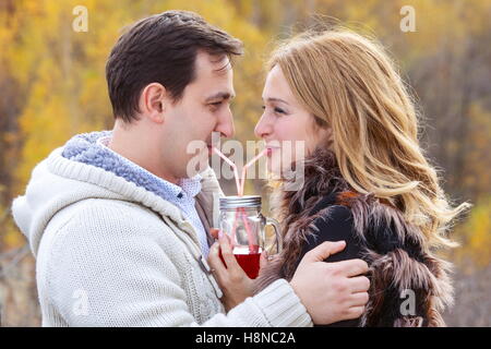 Glückliches junges Paar rote Tee trinken aus dem gleichen Topf Stockfoto