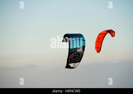 Ein paar der Kite surfen Kites in den Abendhimmel am Strand von Erice, Sizilien Stockfoto