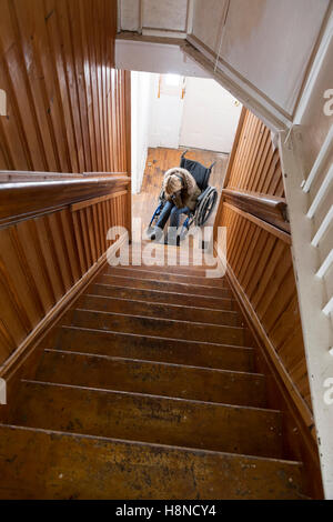 Junge Frau im Rollstuhl am Ende der Treppe Stockfoto