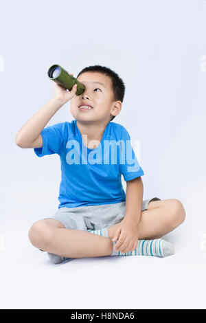 Glücklich kleinen chinesischen jungen Blick durch das Teleskop Stockfoto