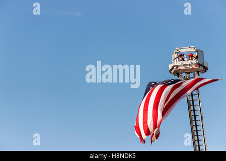 Die Flagge der Vereinigten Staaten von Amerika wird angezeigt, die von erweiterten Leiter der Feuerwehr Rettungsleiter Plattform. Stockfoto