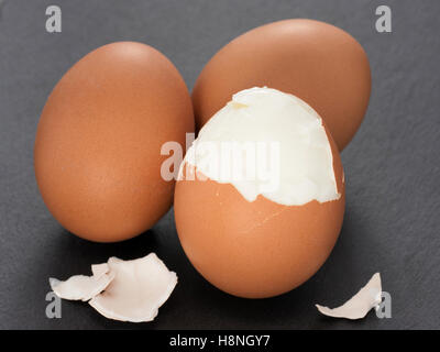 drei gekochten Eiern mit Eierschale auf Schiefer grau hinterlegt. Nahaufnahme Stockfoto
