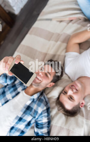 Lächelnd Ay paar machen Selfie im Schlafzimmer Stockfoto