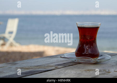 Traditionelle türkische Glas Tee auf dem alten Holztisch in der Nähe von Meer Stockfoto