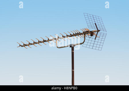 alte TV-Antenne auf blauen Himmelshintergrund isoliert Stockfoto