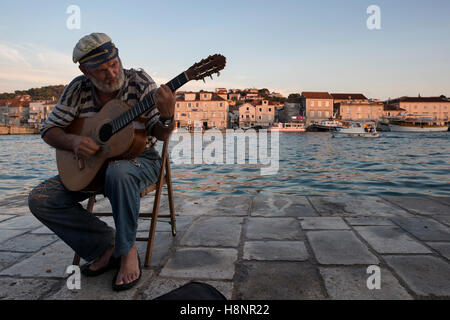 Ein alter Seemann Gitarre im Hafen von Trogir mit Blick auf die Insel Čiovo (im Hintergrund). Trogir, Dalmatien, Kroatien. Stockfoto