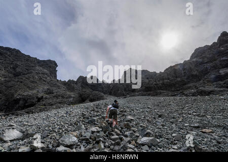 Männliche Hillwalker aufsteigend, der große Stein schießen, um den Gipfel der Sgurr Alasdair (Munro), der Black Cuillin, Skye, Schottland Stockfoto